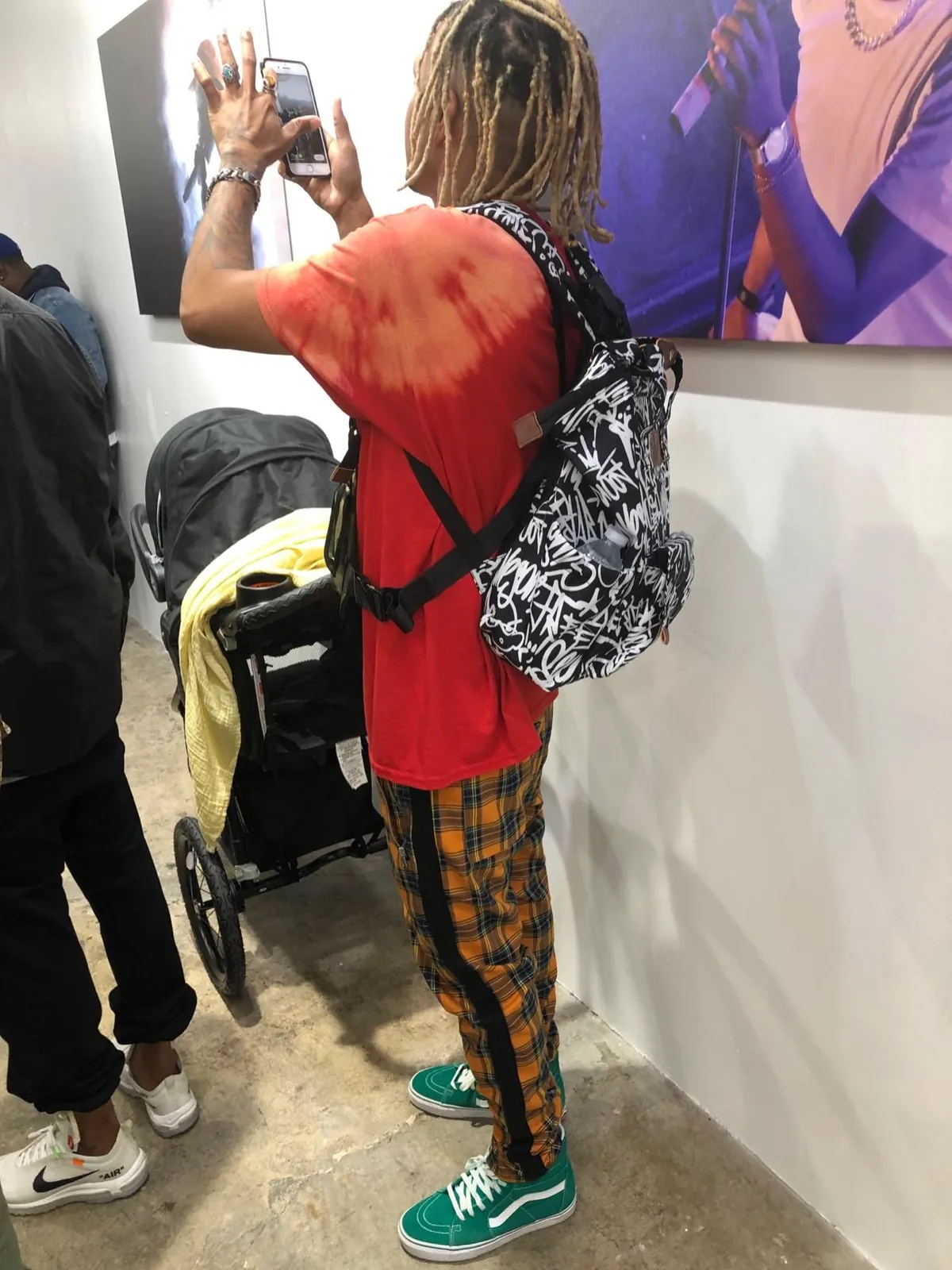 A father wearing the bag in a gallery, a stroller behind him.